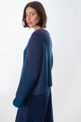 Sweater de punto a rayas verticales blancas y negras, con cuello redondo y mangas largas.