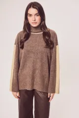 Polera de tejido de punto color marrón jaspeado, con cuello alto y franjas verticales color beige en las mangas. Presenta un calce holgado.