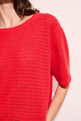 Sweater rojo de algodón con textura calada y mangas cortas.