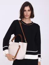 Bolso tipo tote color blanco hueso, con textura granulada y detalles en cuero marrón.