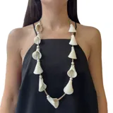 Collar largo con cordón color beige, cuentas plateadas y calas de resina color crema.