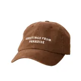 Gorra de seis paneles Rip Curl, color marrón, con visera curva y bordado frontal en color blanco con la frase 'GREETINGS FROM PARADISE'.