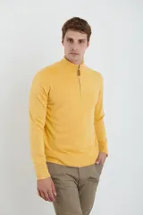 Sweater verde oliva de tejido acrílico con textura similar al cashmere, corte clásico, cuello alto con cierre metálico y tirador de cuerina ecológica.