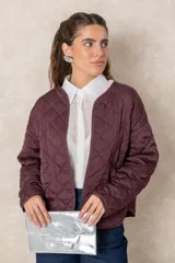 Sobre rectangular de mano con solapa frontal y pieza de agarre integrada. Presenta un acabado laminado plateado con efecto cuarteado que aporta brillo y textura.