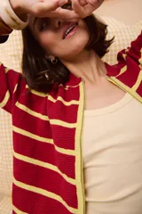 Campera de punto con cierre frontal, diseño de rayas horizontales en tonos verde, verde oscuro y rojo, y textura ondulada en el tejido.