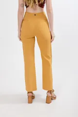 Pantalón mostaza de tela Slubb lycra de algodón elastizada, con corte palazzo y diseño cruzado en la cintura.