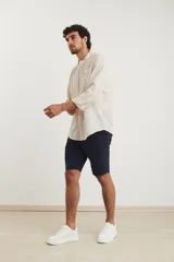Camisa de cuello mao y manga larga, confeccionada en una mezcla de lino y algodón. Presenta un diseño de corte recto con botones en tono natural y un bolsillo pequeño en el pecho.