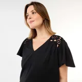Camiseta negra de punto crepé, con escote en V, mangas cortas fluidas y detalles de macramé en los hombros.
