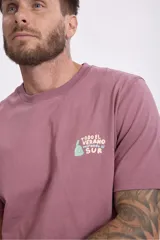 Remera de algodón color verde musgo, de corte clásico con cuello redondo y manga corta. Presenta un pequeño estampado gráfico en el pecho.