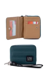 Billetera corta de diseño capitoneado con cierre perimetral y solapa frontal. Cuenta con compartimentos internos para tarjetas y billetes, e incluye una correa de mano desmontable.