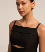 Vestido corto negro con escote cuadrado, breteles finos, corte a la cintura y falda balonê. Presenta un corte en el pecho y cierre con cremallera en la espalda.