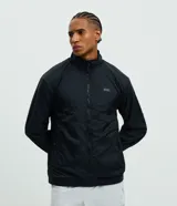 Campera deportiva reversible de manga larga con cierre frontal de cremallera, cuello alto y bolsillos laterales. Confeccionada en poliamida con forro interior de fleece, presenta un pequeño logo estampado en el pecho.