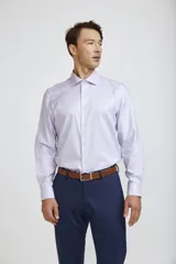 Camisa de vestir blanca de corte clásico, con cuello rígido, cierre frontal de botones y mangas largas con puños abotonados.
