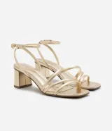 Sandalias doradas de tacón bloque, con tiras finas y cierre de hebilla en el tobillo.