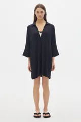 Camisola negra larga tipo vestido, de manga tres cuartos y cuello camisero. Tiene botones delanteros ocultos.