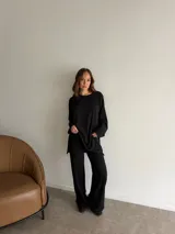 Conjunto de dos piezas de lanilla en color negro, compuesto por una remera de manga larga oversize y un pantalón largo de corte recto y holgado.