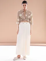 Pantalón palazzo color blanco con cintura alta y dos botones decorativos.
