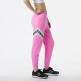 Pantalón de jogging rosa con cintura elástica y cordón ajustable. Presenta una banda lateral blanca con el logo de New Balance repetido.