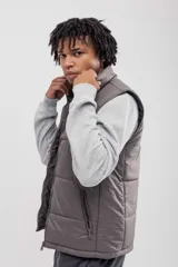 Chaleco puffer color gris topo, con cuello alto y cierre frontal.