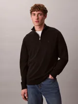 Sweater de punto fino de lana merino, con cuello alto y cierre de media apertura. Presenta mangas largas con puños acanalados y logo de la marca bordado en el pecho.