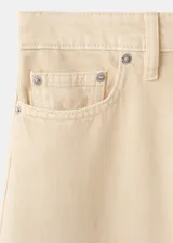 Jeans de corte wide leg en color beige, con tiro medio-alto, bolsillos clásicos y cierre frontal con botón y cremallera.