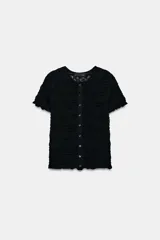 Top de punto negro con textura de nido de abeja, cuello redondo, mangas cortas y cierre frontal con botones.