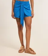 Short pollera corto de viscolino color azul, con cintura elástica y detalle de lazo delantero. Confeccionado en una mezcla de viscosa y lino.
