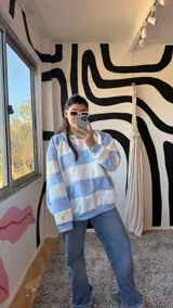 Buzo deportivo celeste y blanco a rayas horizontales, con cuello redondo amarillo y puños y ruedo en celeste.