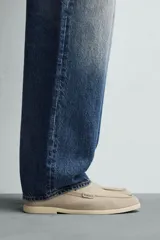 Mocasín casual de hombre confeccionado en piel con acabado serraje en color beige, con detalle de bordón en el empeine y suela fina al tono.