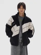 Campera de denim con diseño color block en negro y beige, corte oversized, cuello alto, cierre frontal completo, bolsillos laterales con cierre y puños y cintura elásticos.