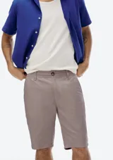 Bermuda de sarga estilo chino en color gris oscuro, con cierre de botón y cremallera, bolsillos laterales y corte recto.