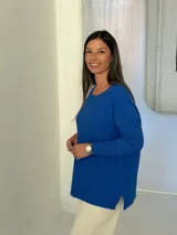 Sweater de punto color azul, con diseño de trenzas horizontales, cuello redondo y mangas largas con puños ajustados.