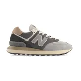 Championes urbanos New Balance modelo 574, con diseño en tonos grises y detalles en marrón. Confeccionados en una combinación de gamuza y malla, cuentan con el logo lateral característico y entresuela con tecnología ENCAP para mayor amortiguación.