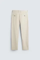 Pantalón chino de corte slim fit, confeccionado en tejido elástico. Presenta bolsillos frontales, bolsillos traseros de vivo con botón y cierre frontal con cremallera y botón.