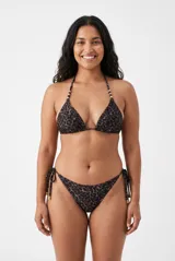 Conjunto de bikini con estampa animal print de leopardo, compuesto por un corpiño triangular con tirantes finos regulables y detalles de cuentas doradas, y una bombacha colaless con tiras laterales ajustables.