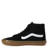Championes Vans modelo Skate Sk8-Hi de caña alta, color negro con la icónica banda lateral en blanco y suela de goma color caramelo. Confeccionados en una combinación de gamuza y lona, cuentan con cuello acolchado y puntera reforzada para mayor durabilidad.