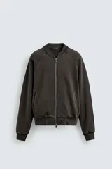 Chaqueta tipo bomber de corte relajado, confeccionada en tejido de mezcla de algodón con interior perchado. Presenta cuello subido, cierre frontal con cremallera, bolsillos de vivo en la cadera y acabados en rib en puños y bajo. Posee un acabado con efecto lavado.
