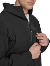 Campera impermeable negra de Tommy Hilfiger, con capucha, cierre de cremallera, dos bolsillos laterales con cierre y logo engomado en la manga.