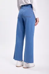 Pantalón de jean ancho de tiro alto, color azul medio, confeccionado en denim elastizado con diseño clásico de cinco bolsillos y terminación deshilachada en el bajo.