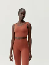 Top deportivo cropped color ladrillo, de sujeción media y tejido Fit_Tech con tecnología 3D.