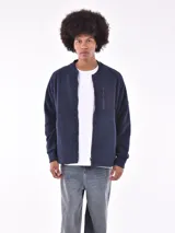 Campera bomber de micropolar azul marino con cierre frontal, cuello redondo y bolsillo vertical con cierre en el pecho.