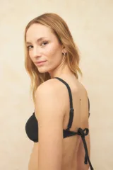 Top de bikini de triángulos fijos color lila, con breteles finos regulables y tela texturizada. Cuenta con un aro en el medio, forro interior y copas desmontables.