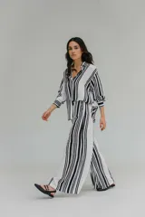 Pantalón de tiro alto con diseño de rayas verticales en blanco y negro, corte amplio y cintura elástica.