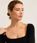 Blusa básica de punto color negro, con escote cuadrado y mangas largas, de corte ajustado al cuerpo.