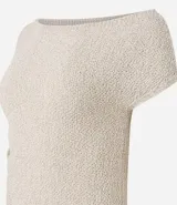 Blusa de punto color crema, con escote asimétrico, mangas cortas, textura y fruncido lateral.