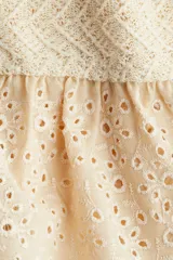 Saco entallado de punto fino con textura, cuello redondo, cierre frontal de botones y detalle de peplum acampanado en tejido de algodón con broderie.