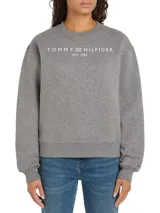 Buzo deportivo gris melange de corte regular con hombros caídos. Presenta el logo de Tommy Hilfiger en blanco centrado en el pecho y un pequeño logo bordado en la manga.