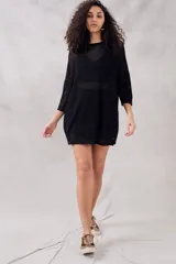 Minivestido negro de calados con mangas 3/4 y cinturón con hebilla metálica.