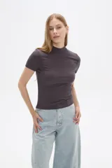 Remera de manga corta, color gris oscuro, confeccionada en tejido acanalado (punto canale) de viscosa, de corte ajustado al cuerpo y cuello alto tipo mock neck.