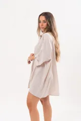 Vestido camisero beige de lino, con escote en V, cuello clásico, mangas tres cuartos regulables y cierre frontal de botones.